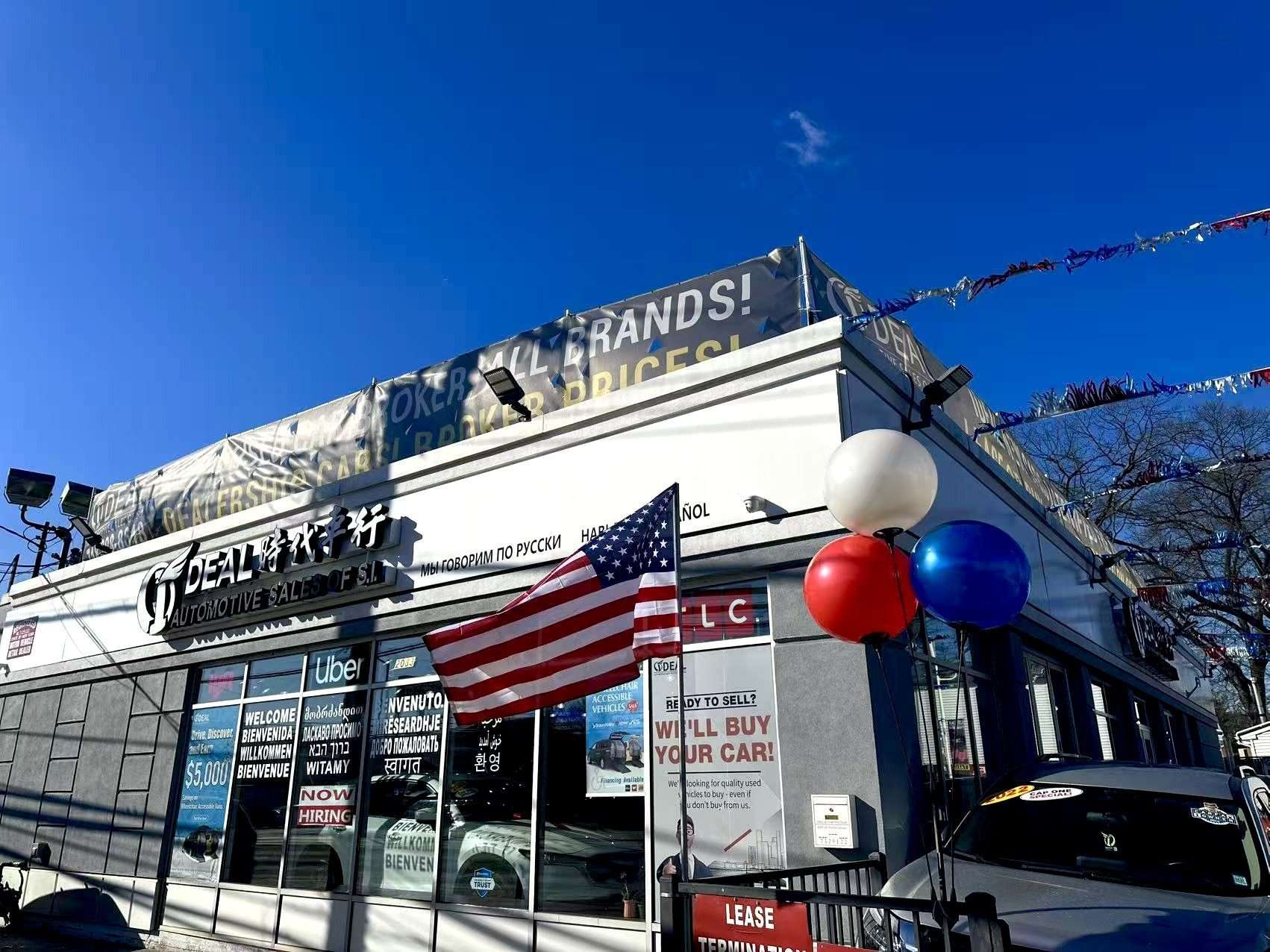 Ideal Auto Sales Staten Island car dealership exterior with balloons and flags.